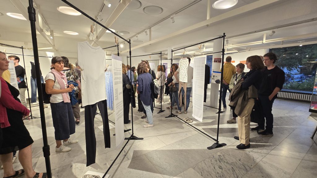 Bild 2: Personen schauen sich die Ausstellung "Was ich anhatte" an bei der Eröffnung im Justus Liebig Haus Darmstadt
